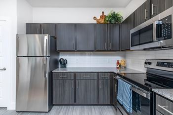 Modern kitchen with granite countertops and dark cabinetry